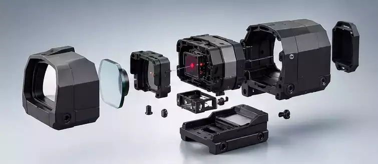 Exploded view of a red dot sight housing and internal components